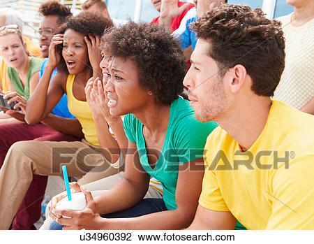 Stock Image - Disappointed Spectators In Team Colors Watching Sports Event. Fotosearch