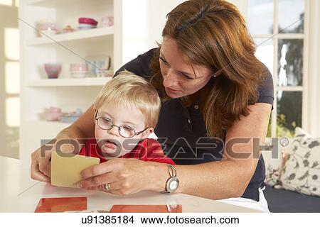 Picture - Downs Syndrome boyhaving speech therapy. Fotosearch