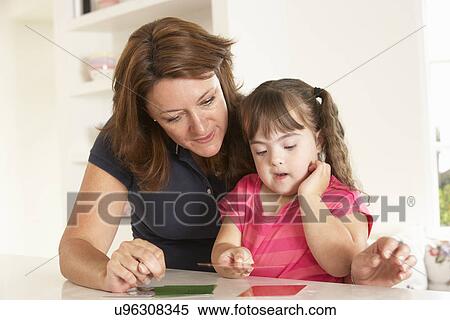 Stock Photography - Downs Syndrome girl having speech therapy. Fotosearch