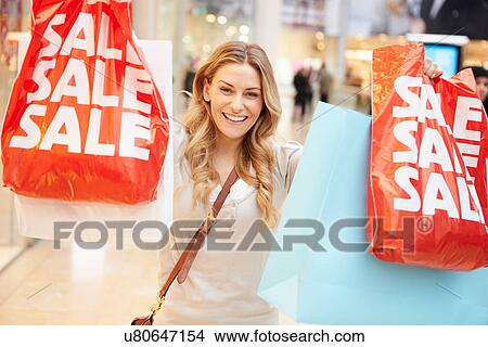Picture - Excited Female Shopper With Sale Bags In Mall. Fotosearch