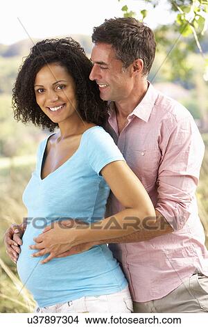 Expectant couple outdoors in countryside View Large Photo Image Picture - Expectant couple outdoors in countryside. Fotosearch