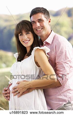 Expectant couple outdoors in countryside View Large Photo Image Stock Image - Expectant couple outdoors in countryside. Fotosearch