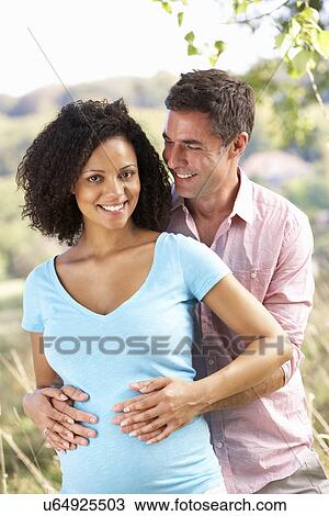 Expectant couple outdoors in countryside View Large Photo Image Stock Image - Expectant couple outdoors in countryside. Fotosearch