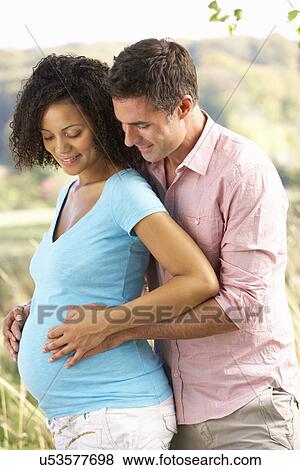 Expectant couple outdoors in countryside View Large Photo Image Stock Photo - Expectant couple outdoors in countryside. Fotosearch