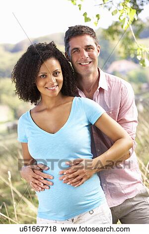 Stock Photo - Expectant couple outdoors in countryside. Fotosearch