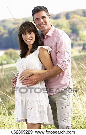 Stock Photo - Expectant couple outdoors in countryside. Fotosearch