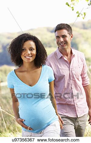 Stock Photo - Expectant couple outdoors in countryside. Fotosearch