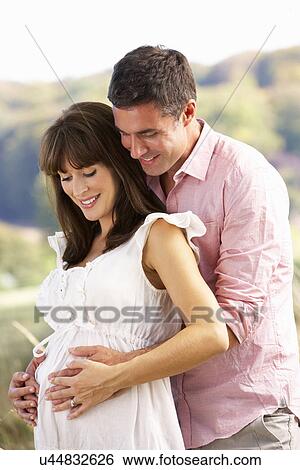 Stock Photograph - Expectant couple outdoors in countryside. Fotosearch
