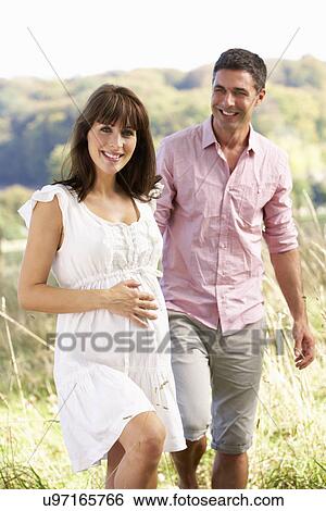 Expectant couple outdoors in countryside View Large Photo Image Stock Photograph - Expectant couple outdoors in countryside. Fotosearch