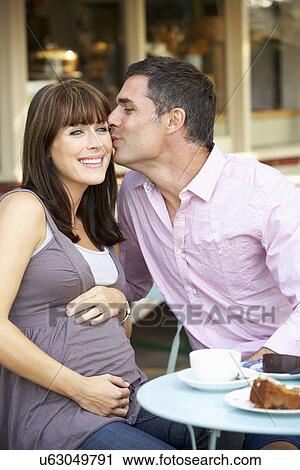 Expectant couple sitting outside café View Large Photo Image Stock Image - Expectant couple sitting outside café. Fotosearch
