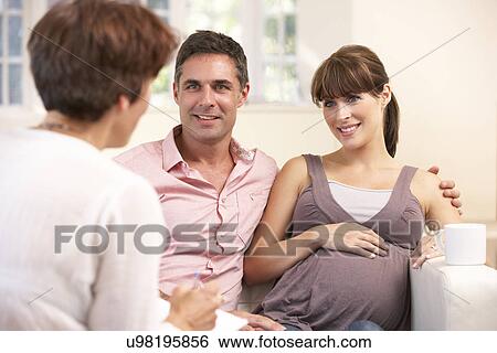 Stock Photograph - Expectant couple talking to midwife. Fotosearch