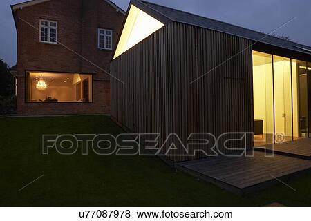 Stock Photo - Exterior Of Modern House With Extension At Night. Fotosearch
