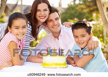 Stock Photo - Family Celebrating Birthday Outdoors With Cake. Fotosearch