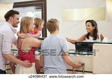 Stock Photo - Family Checking In At Hotel Reception. Fotosearch