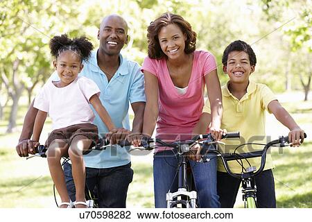 Family cycling in park View Large Photo Image Stock Image - Family cycling in park. Fotosearch