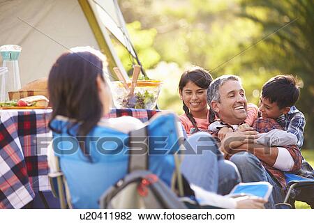 Stock Image - Family Enjoying Camping Holiday In Countryside. Fotosearch