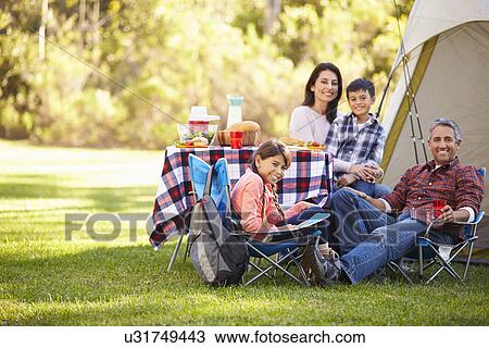 Stock Image - Family Enjoying Camping Holiday In Countryside. Fotosearch