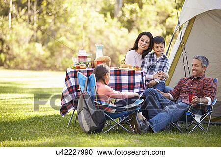 Stock Image - Family Enjoying Camping Holiday In Countryside. Fotosearch