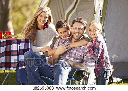 Stock Image - Family Enjoying Camping Holiday In Countryside. Fotosearch