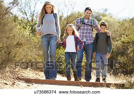 Picture - Family Hiking In Countryside Wearing Backpacks. Fotosearch