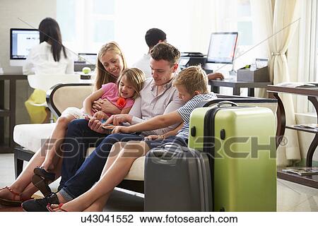 Family In Hotel Lobby Looking At Digital Tablet View Large Photo Image Stock Image - Family In Hotel Lobby Looking At Digital Tablet. Fotosearch
