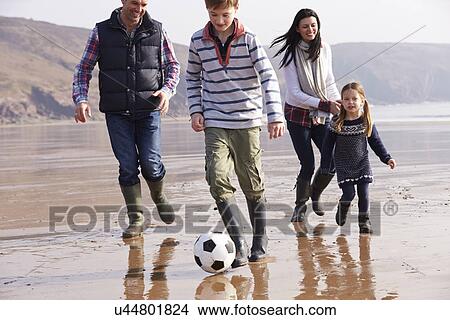 Picture - Family Playing Football On Winter Beach . Fotosearch