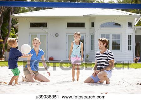 Stock Image - Family Playing Game Of Volleyball In Garden . Fotosearch