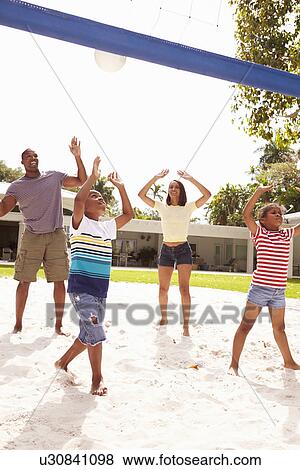 Stock Photo - Family Playing Game Of Volleyball In Garden . Fotosearch