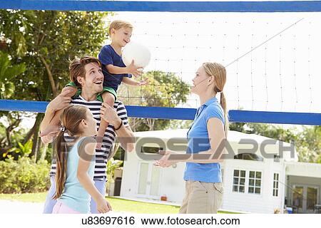 Stock Photograph - Family Playing Game Of Volleyball In Garden . Fotosearch