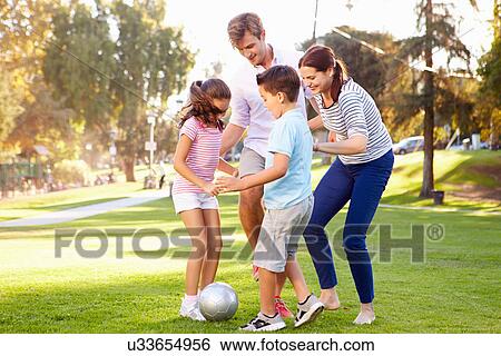 Stock Photograph - Family Playing Soccer In Park Together. Fotosearch