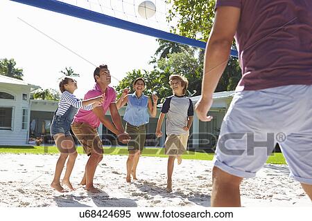 Stock Photography - Family Playing Volleyball In Garden At Home. Fotosearch
