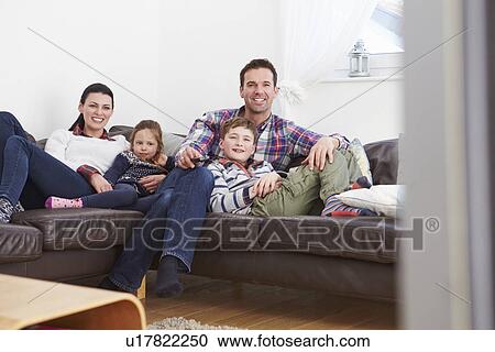 Family Relaxing Indoors Watching Television Together View Large Photo Image Stock Image - Family Relaxing Indoors Watching Television Together. Fotosearch