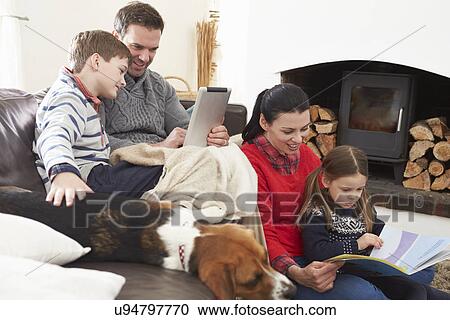 Family Relaxing Reading Book And Using Digital Tablet View Large Photo Image Stock Image - Family Relaxing Reading Book And Using Digital Tablet. Fotosearch