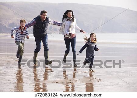 Picture - Family Running Along Winter Beach . Fotosearch