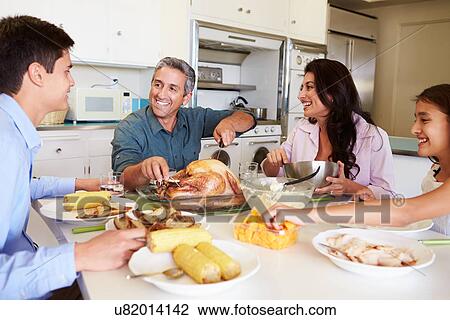Family Sitting Around Table At Home Eating Meal View Large Photo Image Stock Image - Family Sitting Around Table At Home Eating Meal. Fotosearch