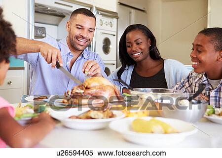 Family Sitting Around Table At Home Eating Meal View Large Photo Image Stock Photography - Family Sitting Around Table At Home Eating Meal. Fotosearch