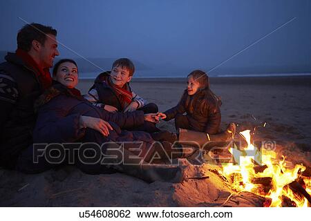 Family Sitting By Fire On Winter Beach View Large Photo Image Stock Image - Family Sitting By Fire On Winter Beach . Fotosearch