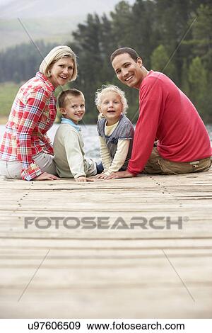 Family sitting on a jetty View Large Photo Image Stock Photo - Family sitting on a jetty. Fotosearch