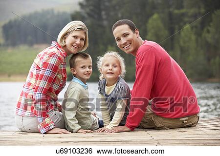 Family sitting on a jetty View Large Photo Image Stock Photograph - Family sitting on a jetty. Fotosearch