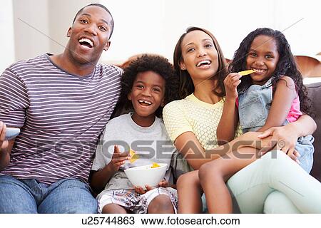 Family Sitting On Sofa Watching TV Together View Large Photo Image Stock Image - Family Sitting On Sofa Watching TV Together. Fotosearch