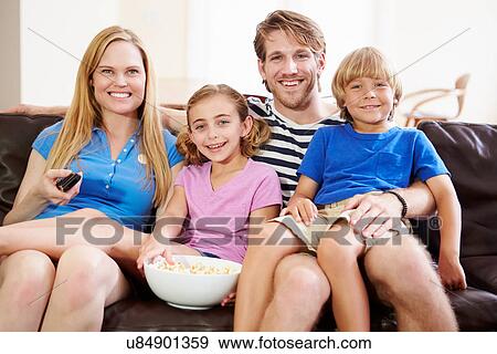 Family Sitting On Sofa Watching TV Together View Large Photo Image Stock Photo - Family Sitting On Sofa Watching TV Together. Fotosearch