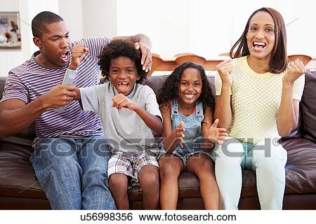 Family Sitting On Sofa Watching TV Together View Large Photo Image Stock Photograph - Family Sitting On Sofa Watching TV Together. Fotosearch