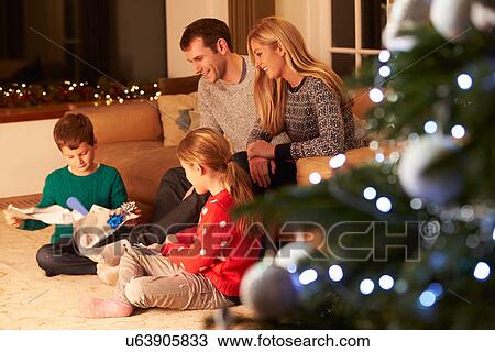 Family Unwrapping Gifts By Christmas Tree View Large Photo Image Stock Image - Family Unwrapping Gifts By Christmas Tree. Fotosearch