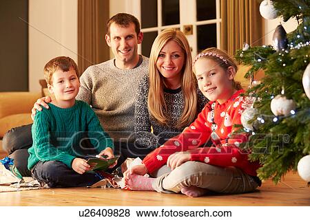 Family Unwrapping Gifts By Christmas Tree View Large Photo Image Stock Photo - Family Unwrapping Gifts By Christmas Tree. Fotosearch
