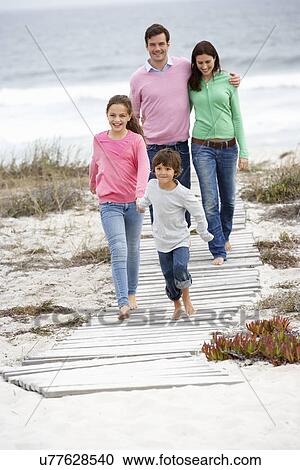 Stock Image - Family walking by the sea. Fotosearch