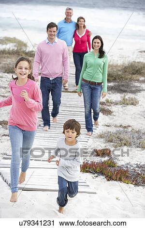 Stock Image - Family walking by the sea. Fotosearch