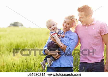 Family Walking In Field Carrying Young Baby Son View Large Photo Image Stock Photography - Family Walking In Field Carrying Young Baby Son. Fotosearch