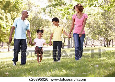 Stock Photograph - Family walking in park. Fotosearch