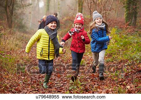 Stock Photography - Family Walking Through Winter Woodland. Fotosearch