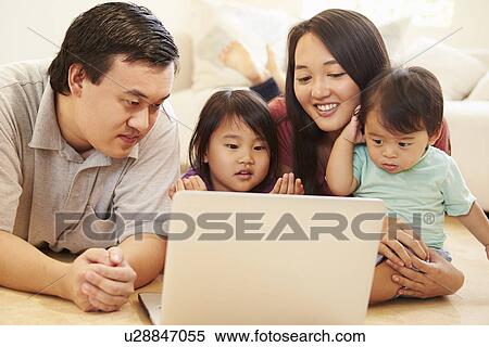 Stock Photography - Family Watching Movie On Laptop At Home. Fotosearch